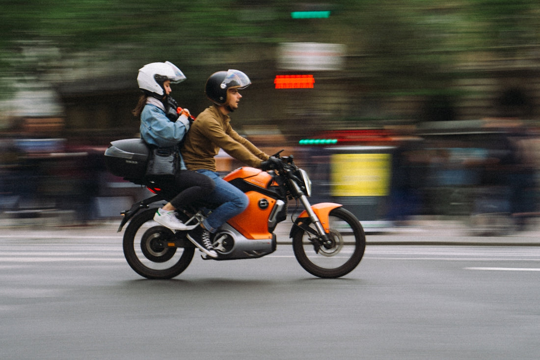 a man and a woman riding a motorcycle
