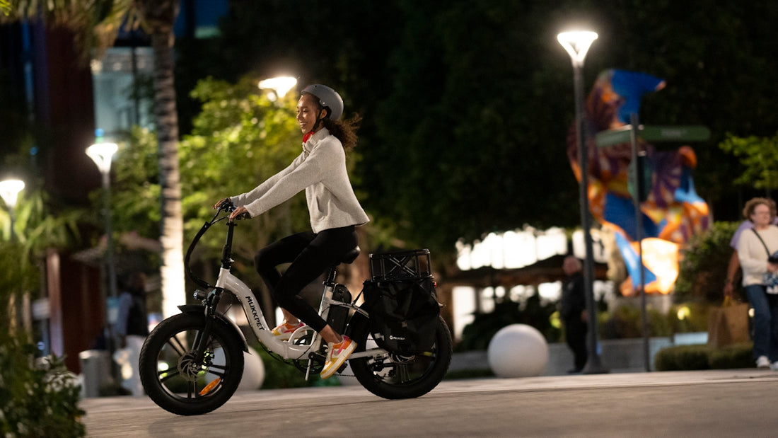 a woman riding a scooter on a city street at night
