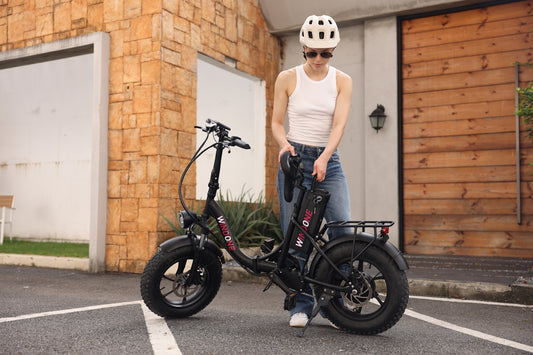 A woman standing next to a black bike in a parking lot