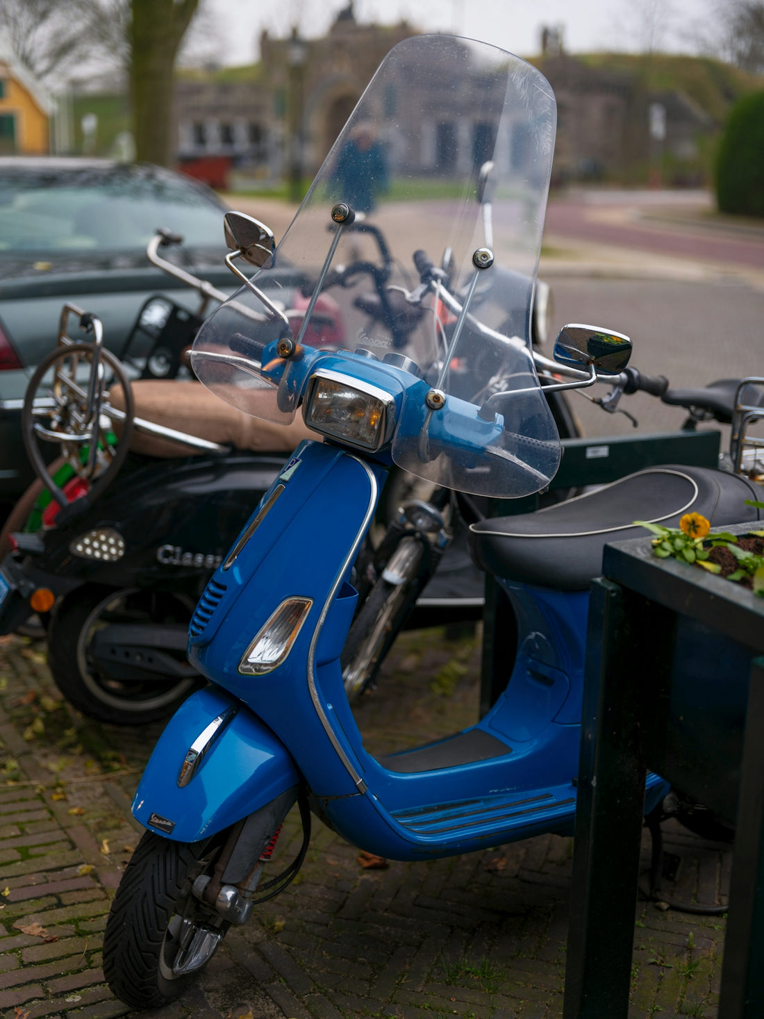 A blue scooter parked next to a table with food on it
