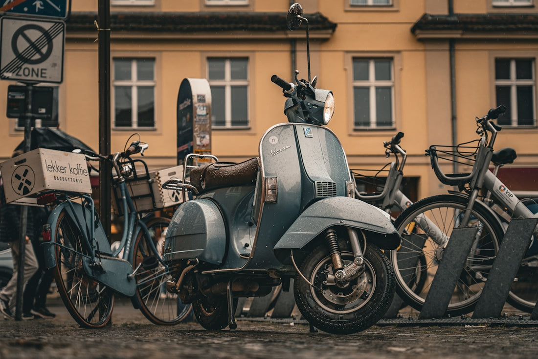 Scooter and bicycles parked in front of a building.